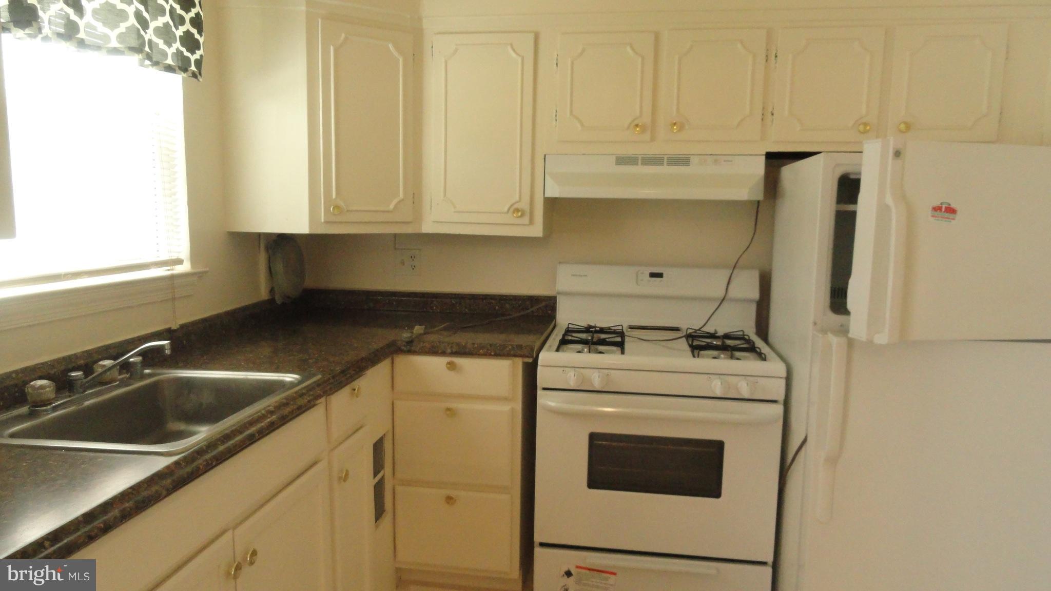 1911 Addison Road South District Heights, MD 20747 - Photo 6 of 15 a kitchen with a sink stove and cabinets