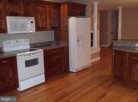 20140 Fort Valley Road Strasburg, VA 22657 - Photo 12 of 25 a kitchen with a white stove top oven and cabinets