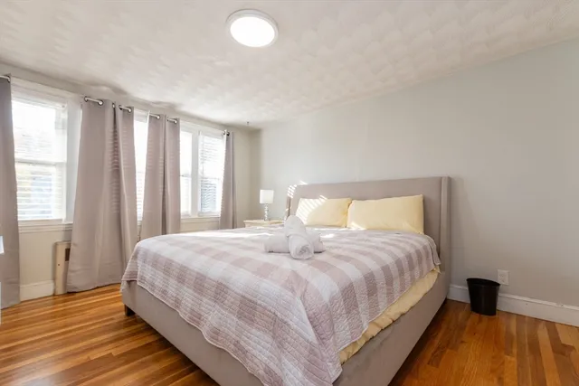 a bedroom with a bed and wooden floor