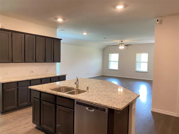 a kitchen with a sink cabinets and wooden floor