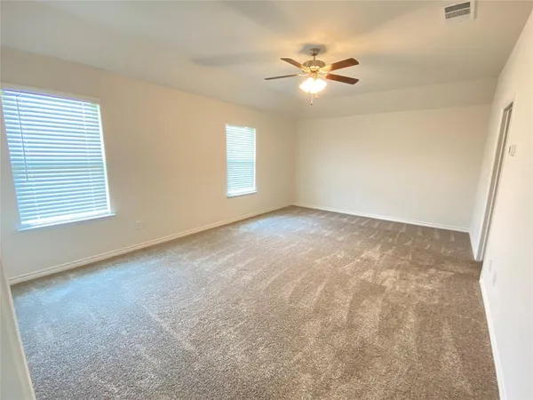 an empty room with windows and fan