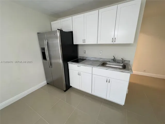 a kitchen with a refrigerator sink and cabinets