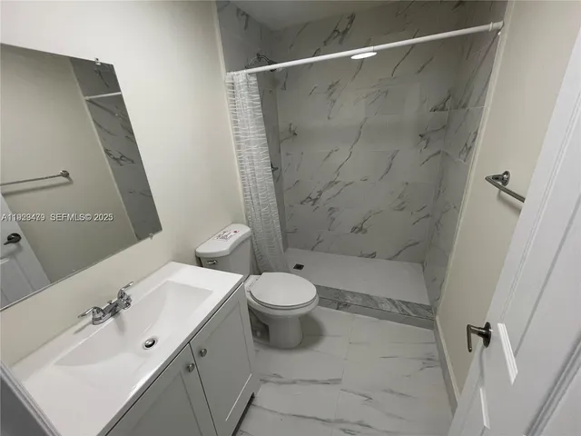a bathroom with a sink mirror toilet and shower