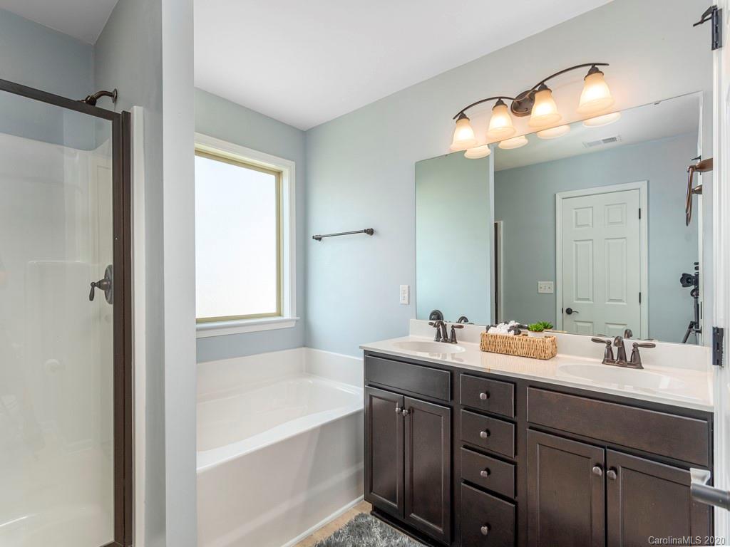 189 North River Road Fletcher, NC 28732 - Photo 15 of 27 a bathroom with a tub sink double vanity and mirror
