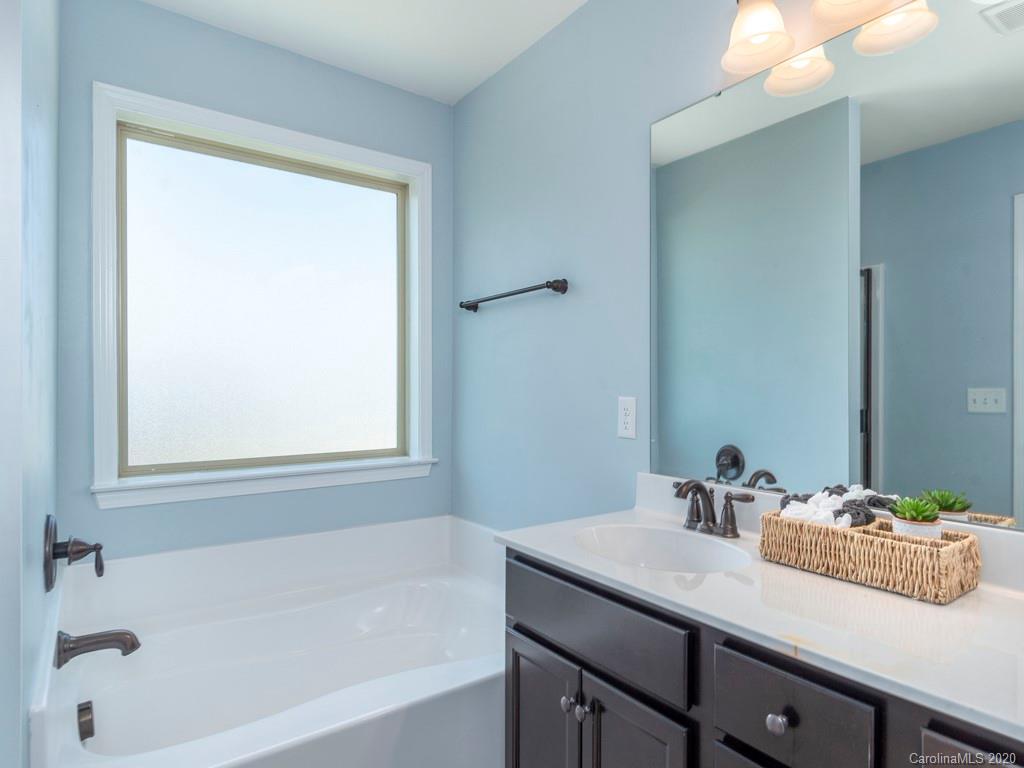 189 North River Road Fletcher, NC 28732 - Photo 16 of 27 a bathroom with a granite countertop sink and a bathtub