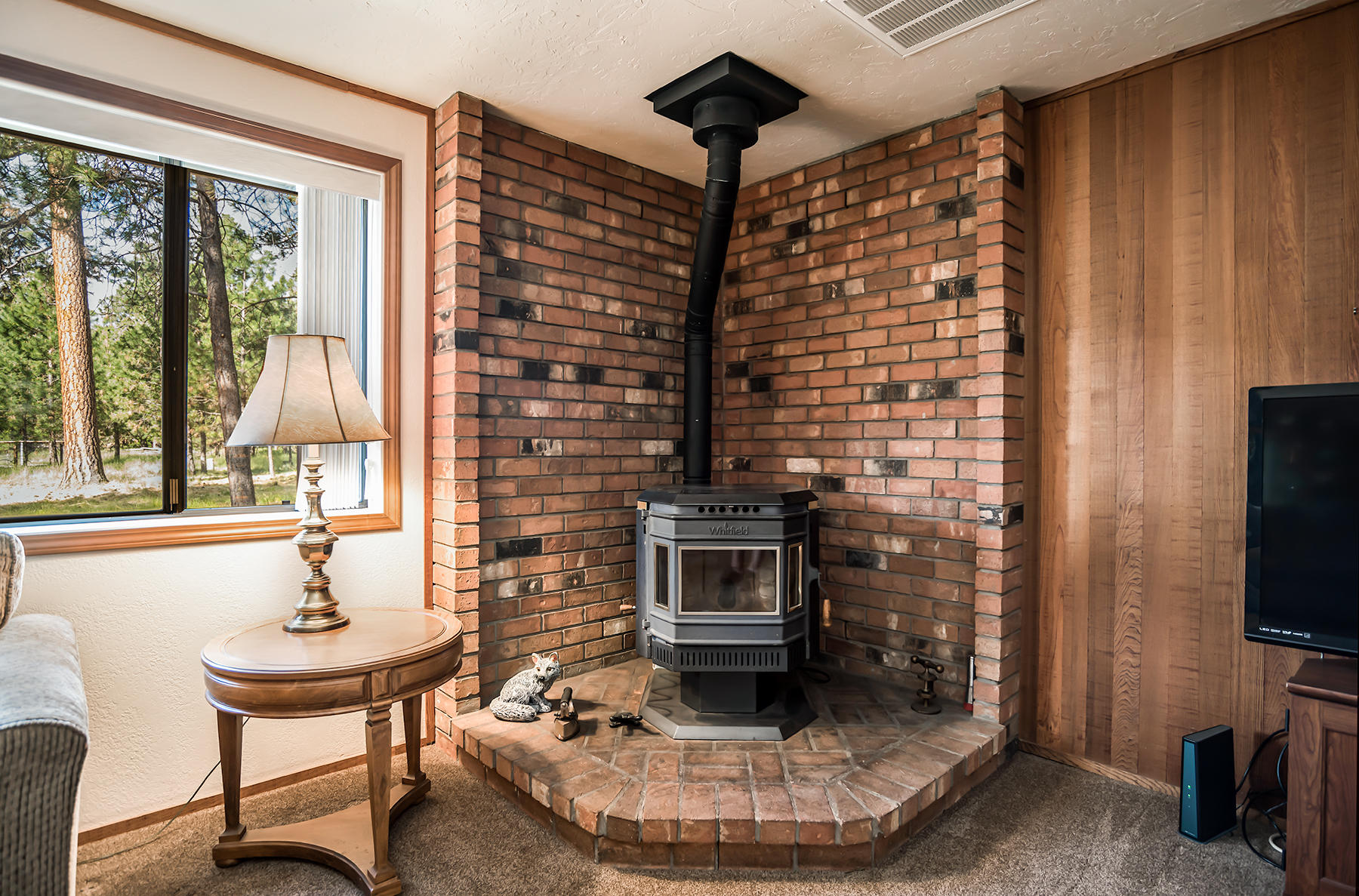 14557 Crossroads Loop Sisters, OR 97759 - Photo 13 of 25 Corner pellet stove on a brick hearth to keep you cozy!