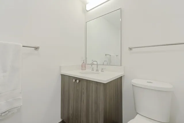 a bathroom with a sink a toilet and a mirror