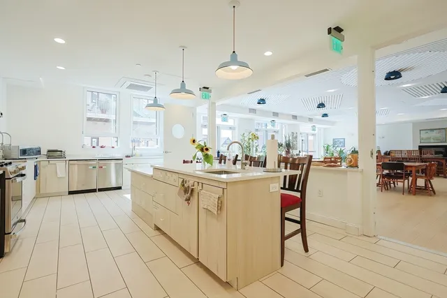 a large white kitchen with lots of counter space and furniture