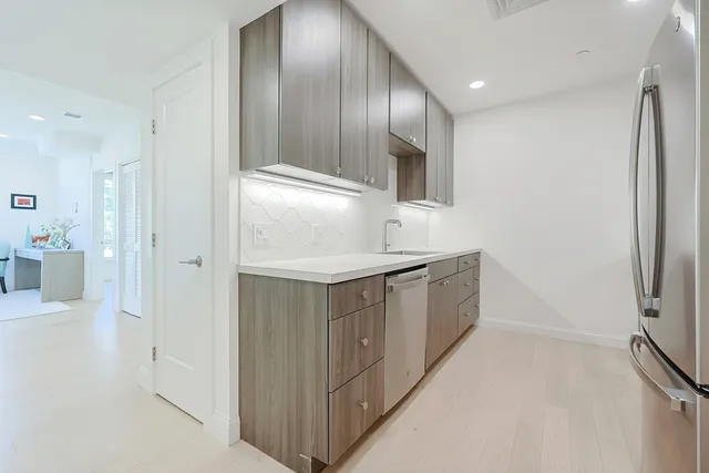 a kitchen with stainless steel appliances a refrigerator and a sink