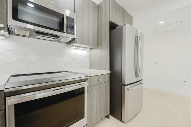 a view of a living room with stainless steel appliances and cabinets