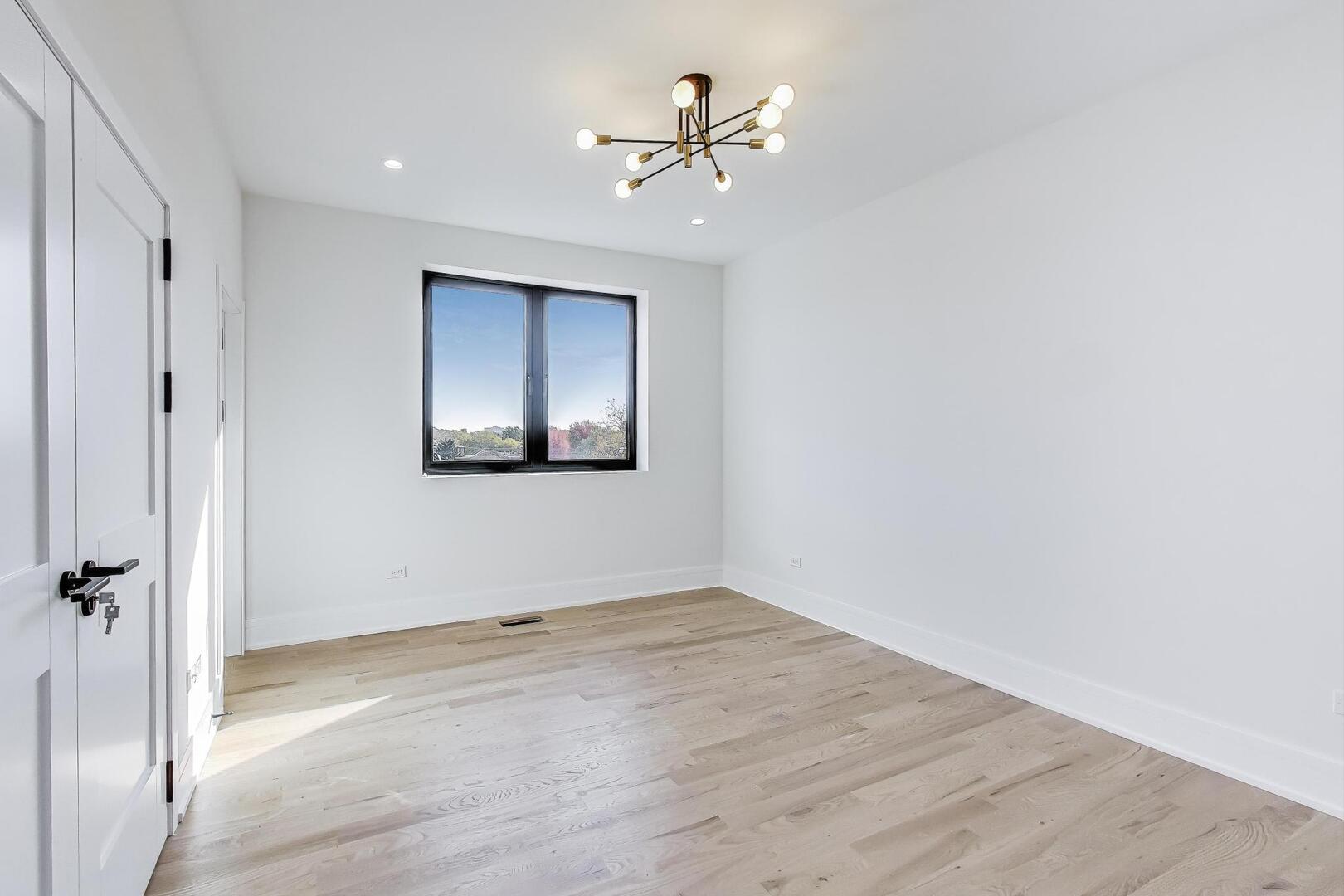 2307 West Foster Avenue, Unit 1 Chicago, IL 60625 - Photo 25 of 34 wooden floor in an empty room with a window