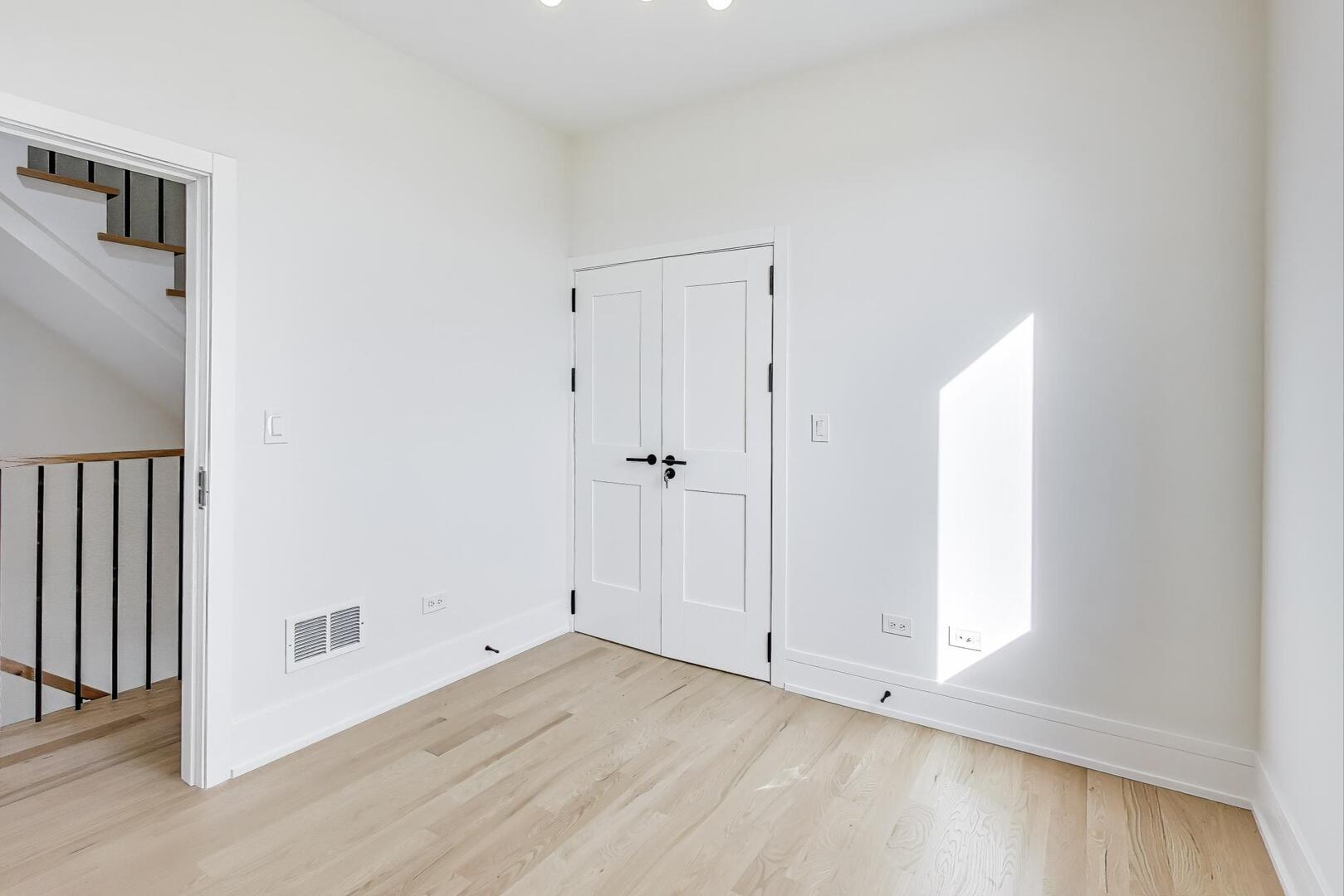 2307 West Foster Avenue, Unit 1 Chicago, IL 60625 - Photo 31 of 34 an empty room with wooden floor and windows