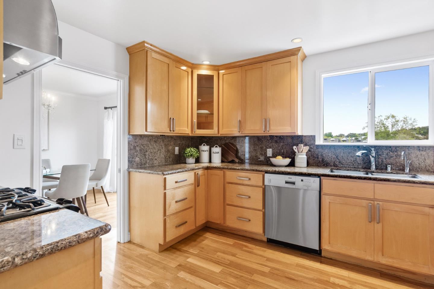511 Bayview Avenue Millbrae, CA 94030 - Photo 18 of 36 a kitchen with stainless steel appliances granite countertop a stove a sink and white cabinets with wooden floor
