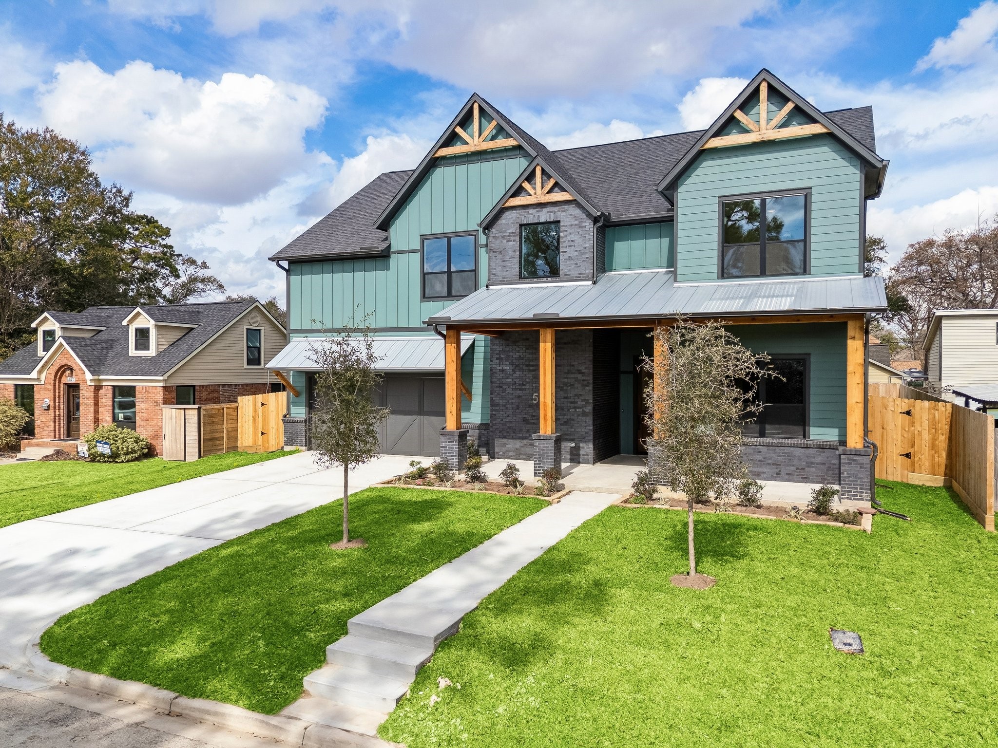 Stunning curb appeal with an extended 30ft front porch. The black brick, metal roof over the garage, and wood accents make it one of a kind.