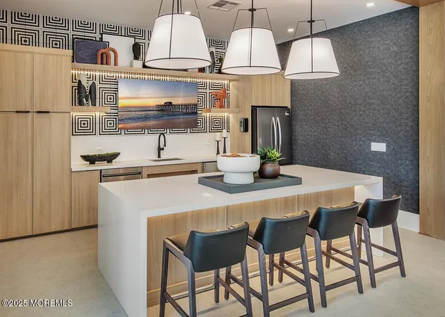 a kitchen with stainless steel appliances granite countertop a sink dishwasher a stove and a dining table with wooden floor