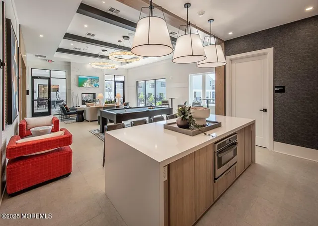 a living room with furniture a flat screen tv and kitchen view