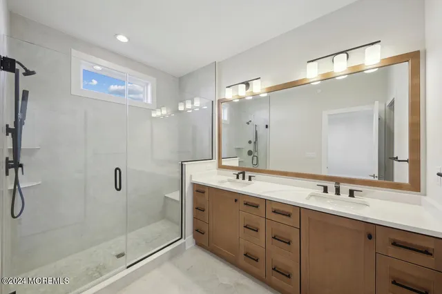 a bathroom with a double vanity sink mirror and shower