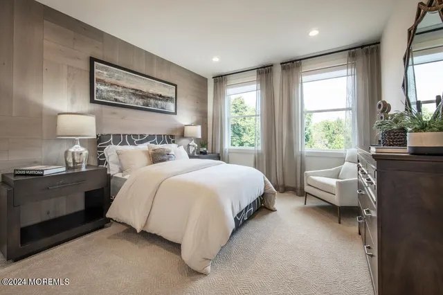 a bedroom with a large bed and windows