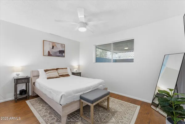 a bedroom with a bed a rug and wooden floor