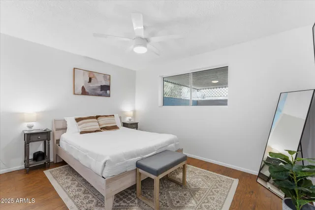 a bedroom with a bed a rug and wooden floor