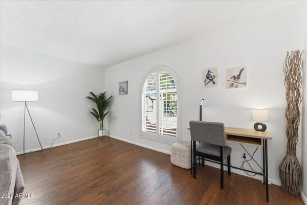 a view of a workspace with furniture and a window