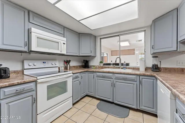 a kitchen with cabinets appliances a sink and a window