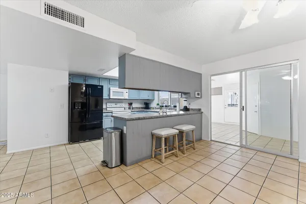 a kitchen with white cabinets and refrigerator