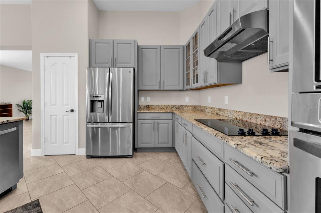 25409 Durango Court Punta Gorda, FL 33955 - Photo 17 of 46 a kitchen with white cabinets and stainless steel appliances