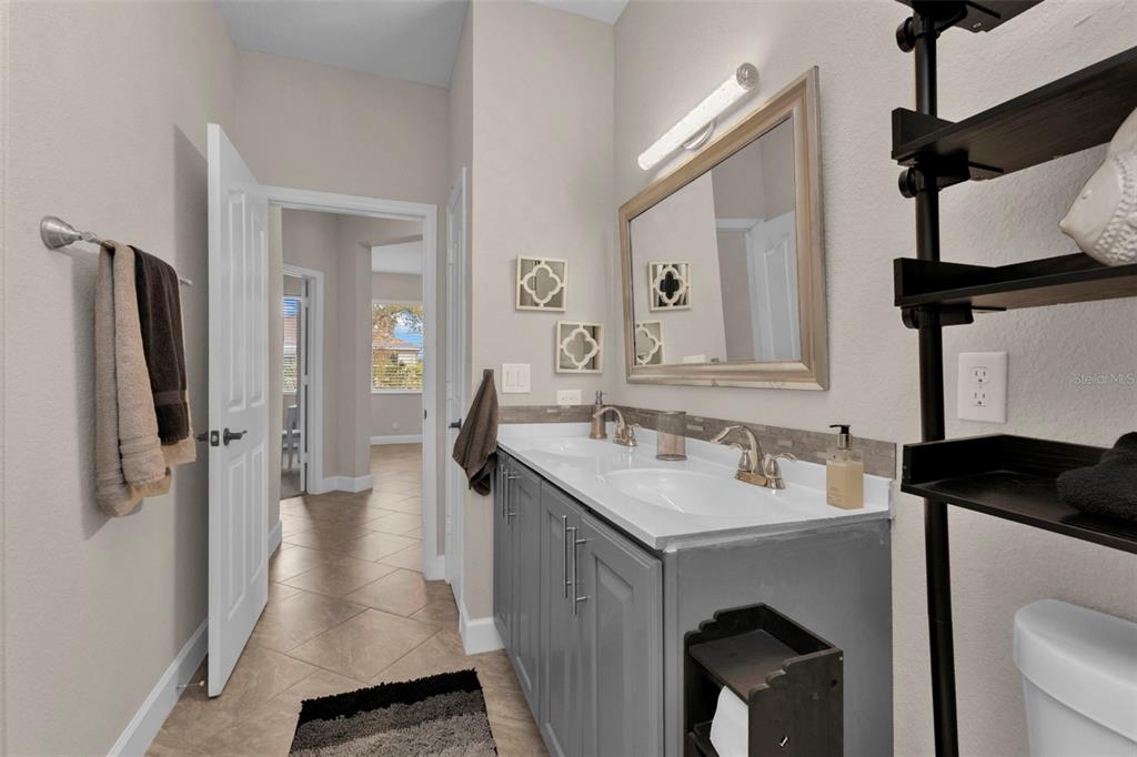 25409 Durango Court Punta Gorda, FL 33955 - Photo 34 of 46 a en suite bathroom with a sink vanity and a mirror