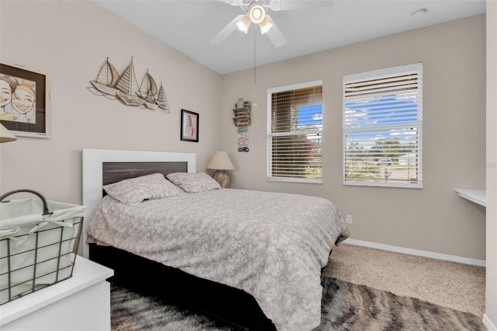 25409 Durango Court Punta Gorda, FL 33955 - Photo 36 of 46 a bedroom with a bed and a chandelier