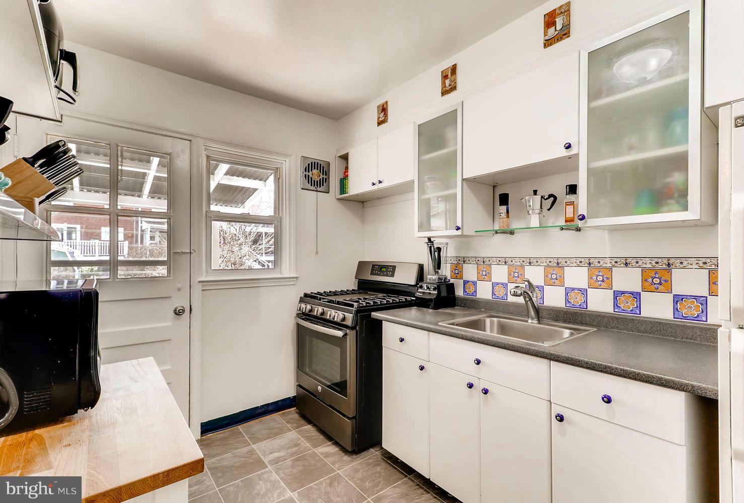 1753 Amuskai Road Baltimore, MD 21234 - Photo 11 of 28 a kitchen with stainless steel appliances white cabinets and a window