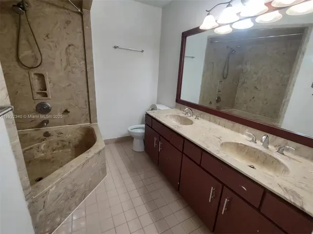 a spacious bathroom with a granite countertop tub sink and mirror