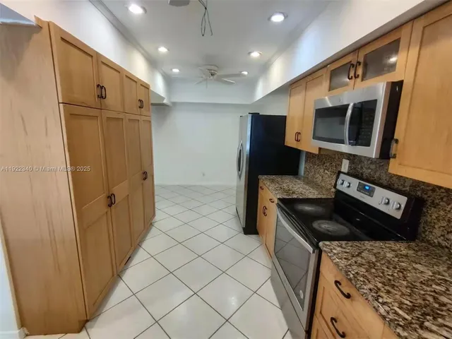 a kitchen with stainless steel appliances granite countertop a refrigerator and a stove