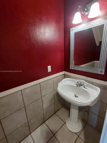 a bathroom with a sink a mirror and a light fixture