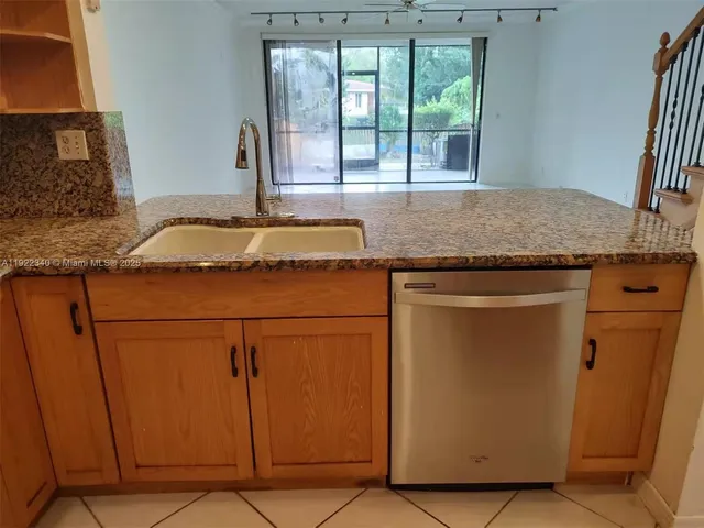 a kitchen with granite countertop cabinets and window