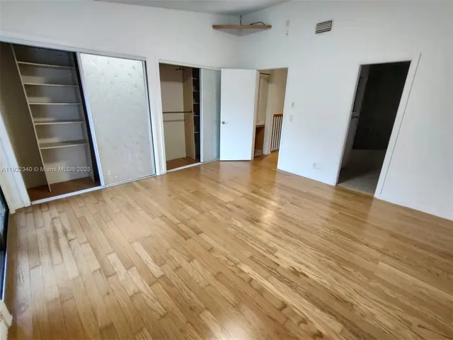 an empty room with wooden floor and closet