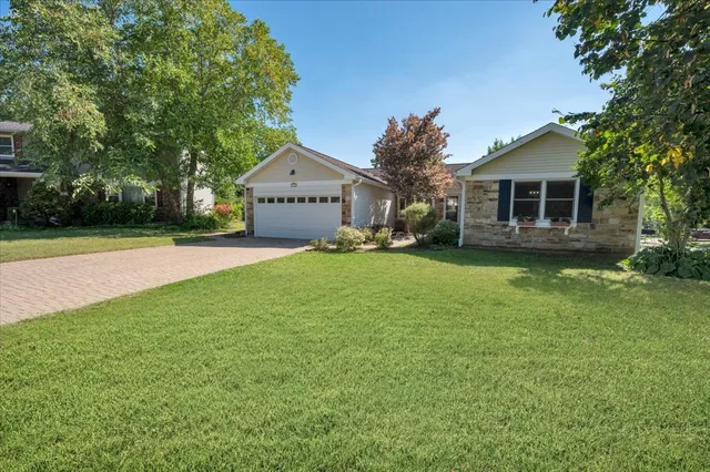 a front view of a house with a yard and trees