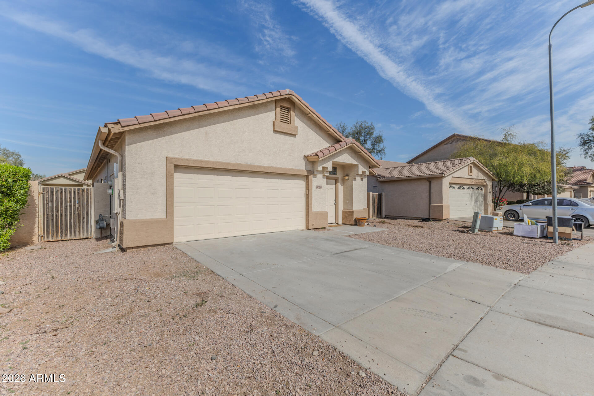 8320 West Apache Street Tolleson, AZ 85353 - Photo 2 of 31 a view of a house with a yard and garage