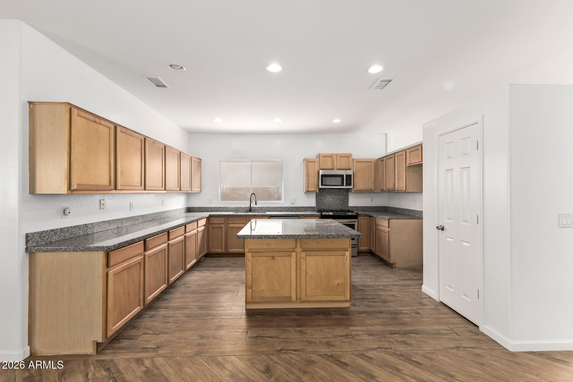 8320 West Apache Street Tolleson, AZ 85353 - Photo 10 of 31 a large kitchen with stainless steel appliances kitchen island granite countertop a large counter top and sink