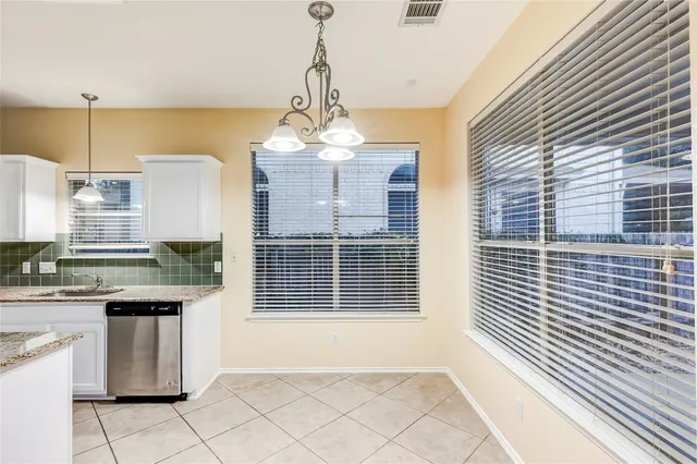 a kitchen with kitchen island stainless steel appliances a window and cabinets