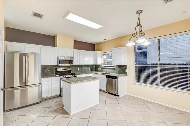 a kitchen with stainless steel appliances granite countertop a stove sink and refrigerator