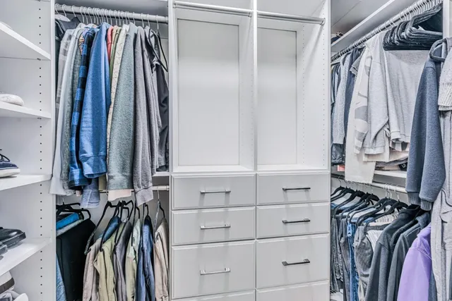 a view of walk in closet with clothes and shoes