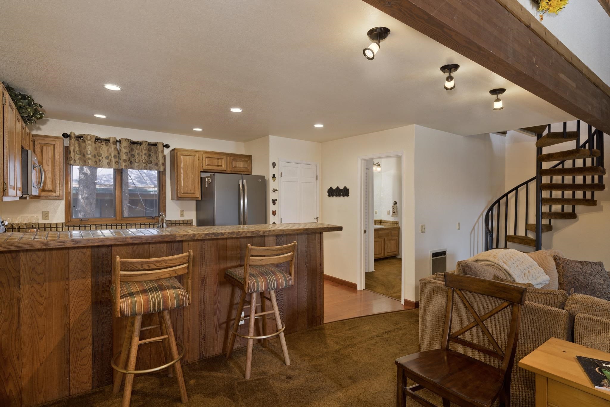 484 Manzanita Road, Unit 16 Mammoth Lakes, CA 93546 - Photo 15 of 34 a kitchen with stainless steel appliances kitchen island granite countertop a dining table chairs and granite counter tops