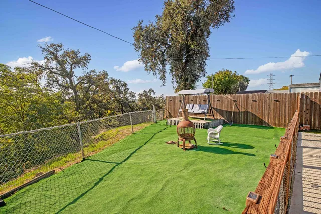 a view of a house with backyard sitting area and garden