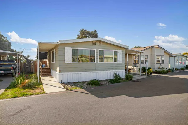 a front view of a house with a garden and trees