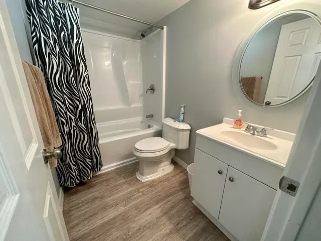 a bathroom with a sink a toilet a mirror and shower
