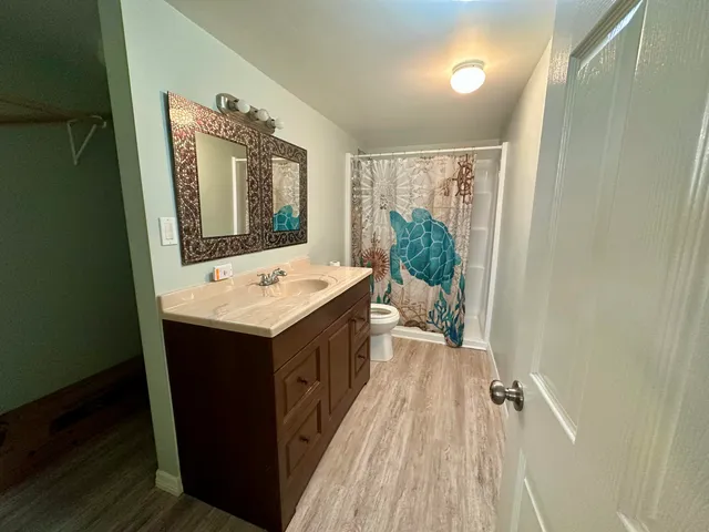 a view of bathroom with a sink mirror and tub