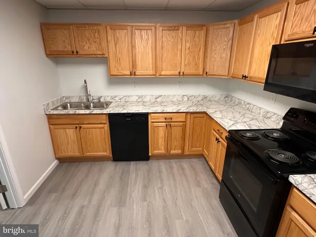a kitchen with granite countertop cabinets stainless steel appliances and a sink