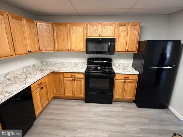 a kitchen with granite countertop a refrigerator stove top oven and sink