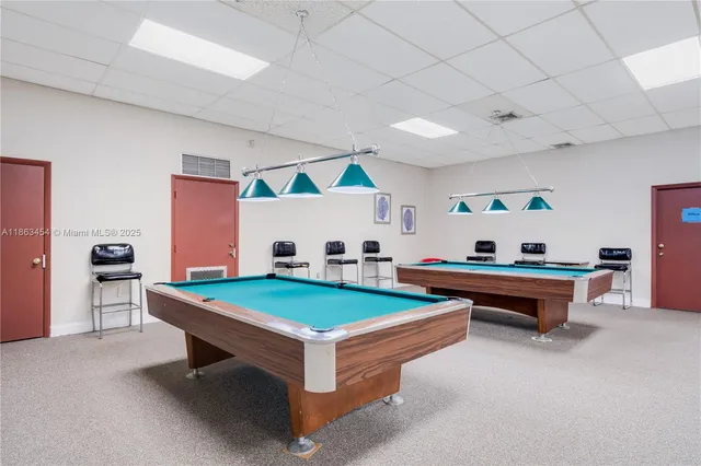 a living room with furniture pool table and flat screen tv